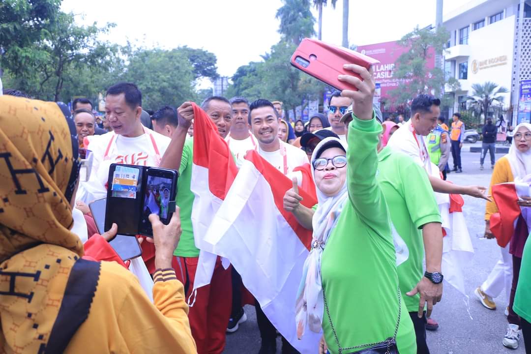 Pj Walikota Pekanbaru Risnandar Mahiwa membagikan secara simbolis Bendera Merah Putih bersempena kegiatan pembagian 10 juta bendera merah putih secara nasional.