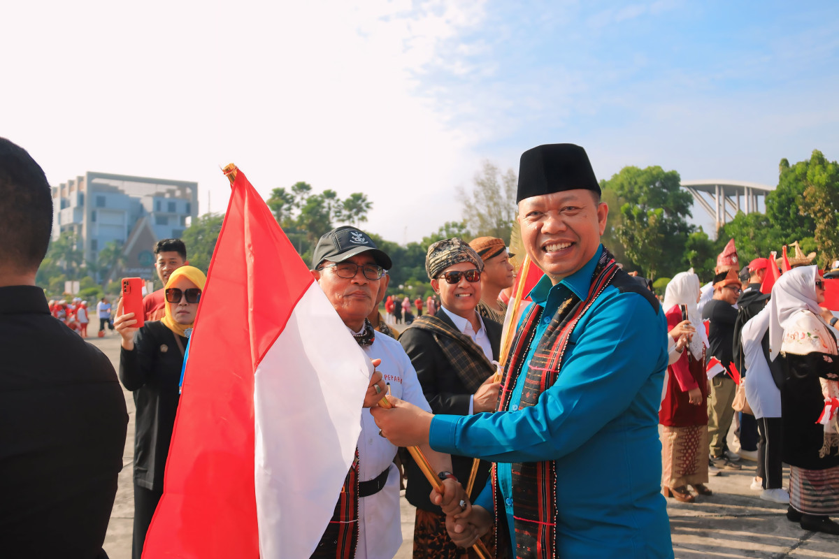 Sekretaris Daerah Kota Pekanbaru Indra Pomi Nasution, S.T., M.Si Membagikan Bendera Merah Putih Kepada Masyarakat dalan Gerakan Pembagian Bendera Merah Putih.