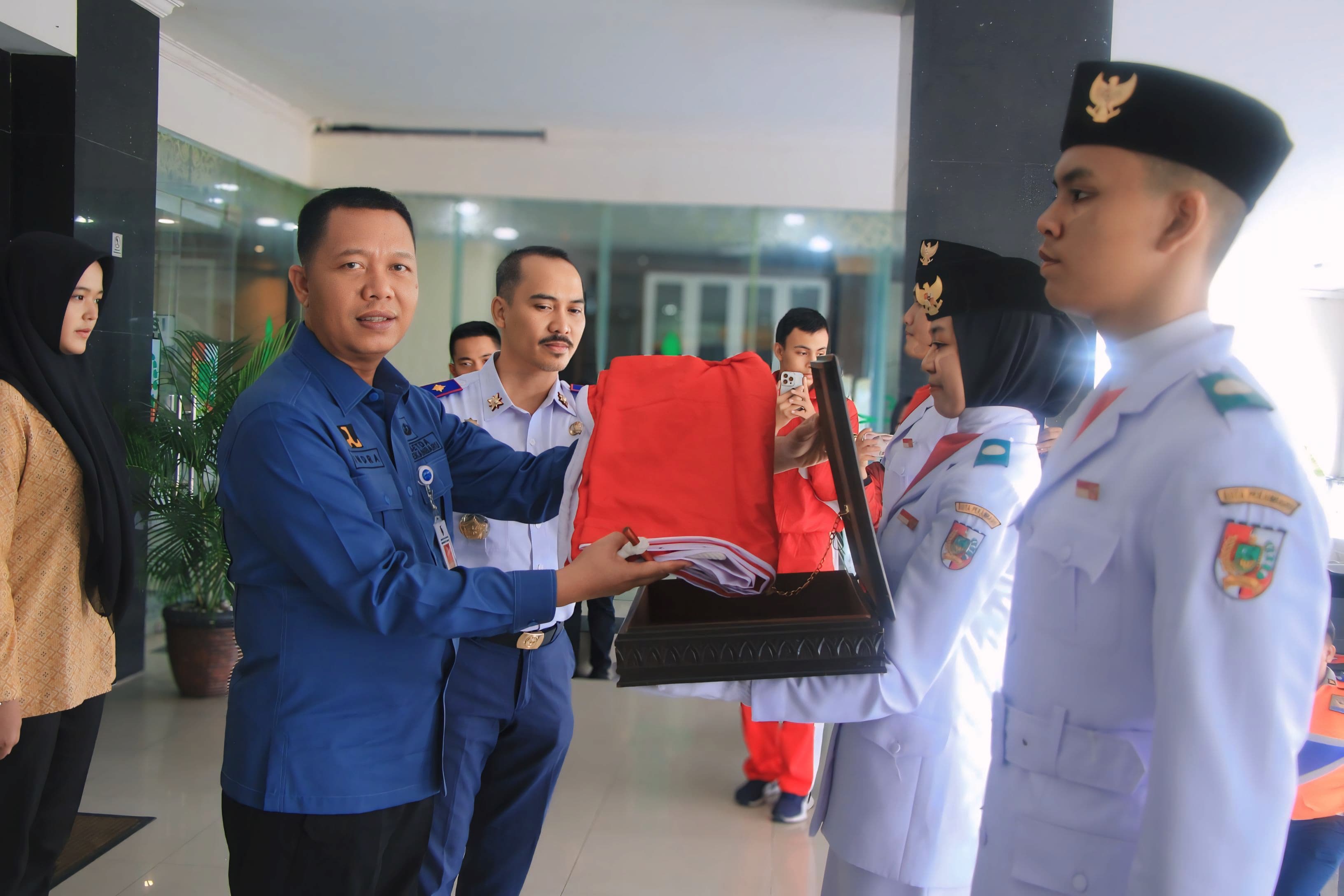Sekdako Pekanbaru Indra Pomi Nasution menerima duplikat bendera pusaka Merah Putih dari pasukan pengibar bendera pusaka