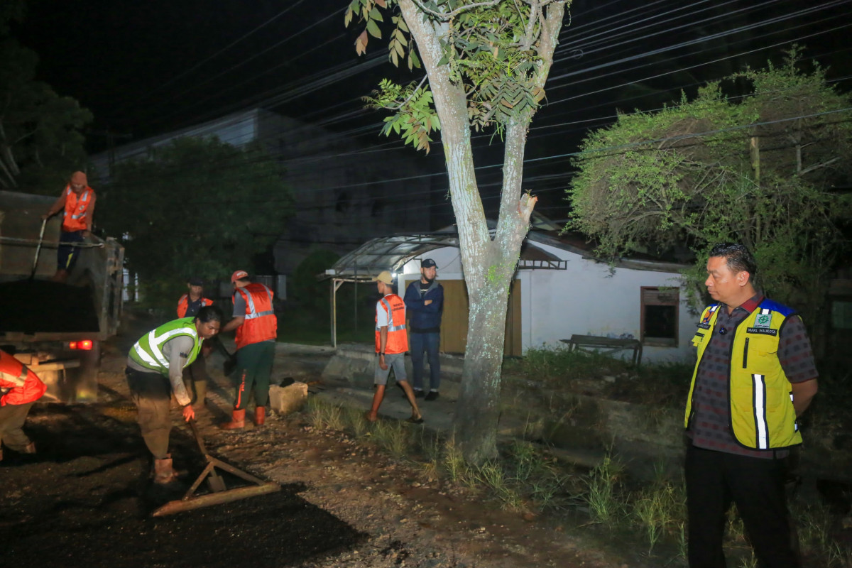 Wakil Wali Kota Pekanbaru Markarius Anwar, meninjau proses perbaikan jalan berlubang di sejumlah titik pada Jumat (21/2/2025) malam.