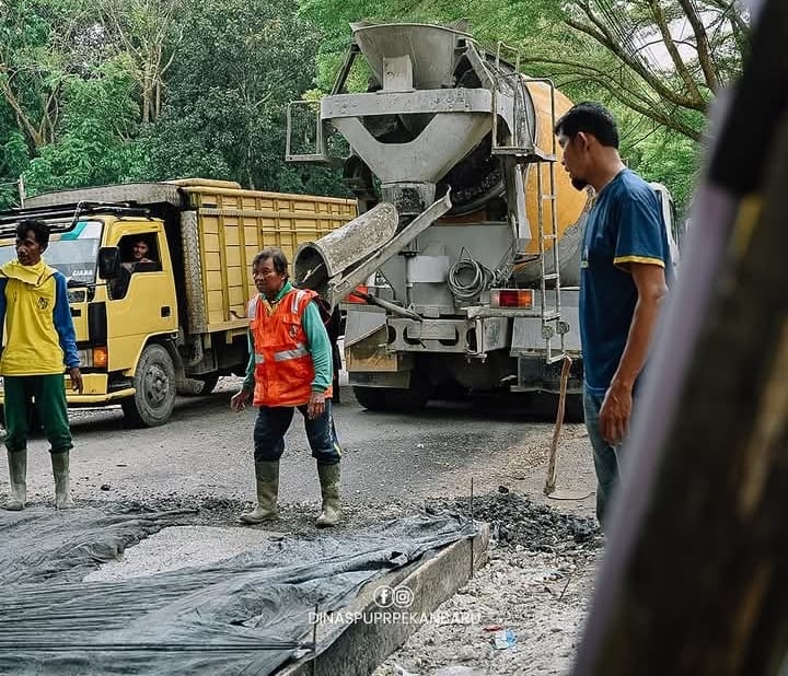 Sejumlah pekerja tengah melakukan semenisasi lanjutan badan Jalan Bukit Barisan.